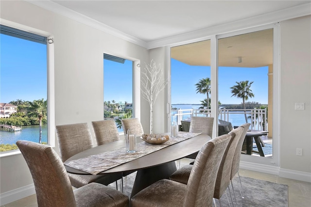 tiled dining space with a water view and ornamental molding