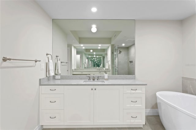 bathroom featuring a tub, tile floors, and vanity