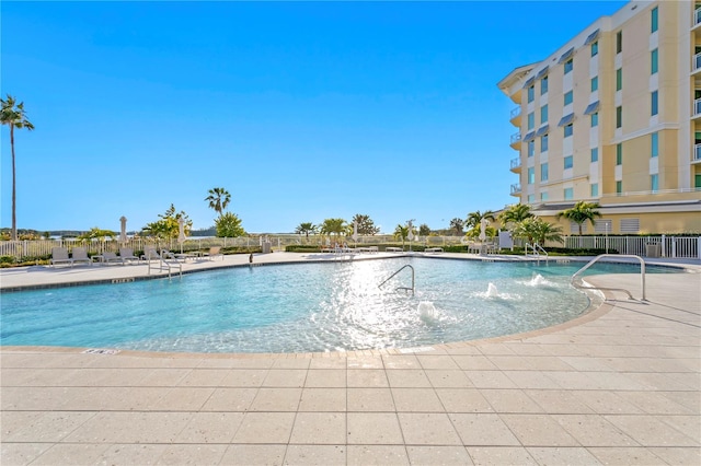 view of swimming pool with pool water feature and a patio