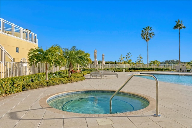 view of swimming pool featuring a hot tub