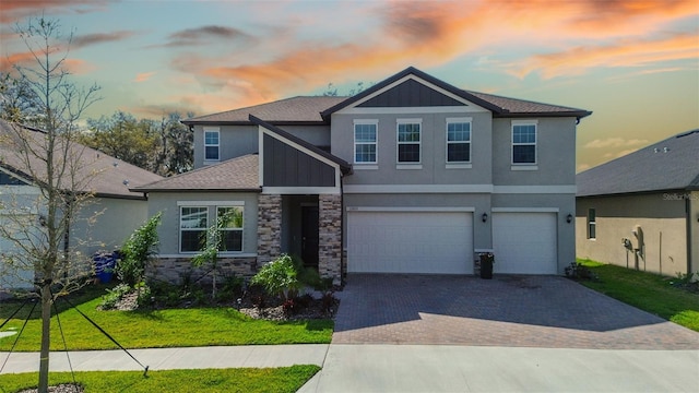 craftsman inspired home featuring a garage and a yard