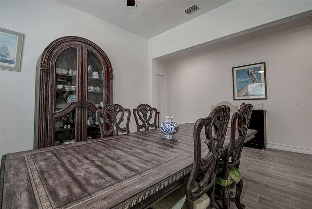 dining room with ceiling fan and dark wood-type flooring