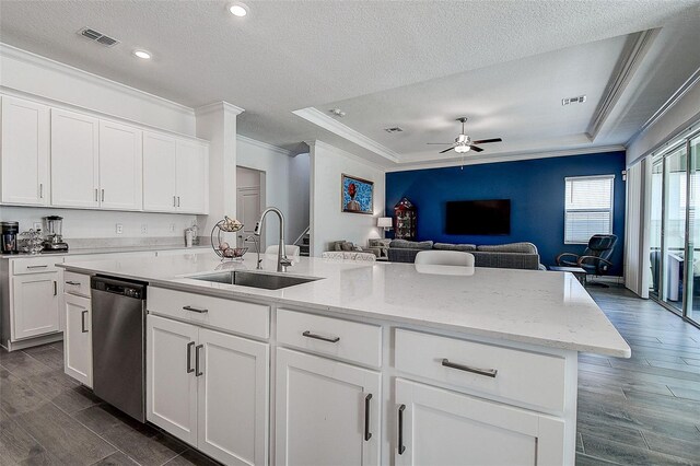 kitchen featuring dishwasher, ceiling fan, sink, and a tray ceiling