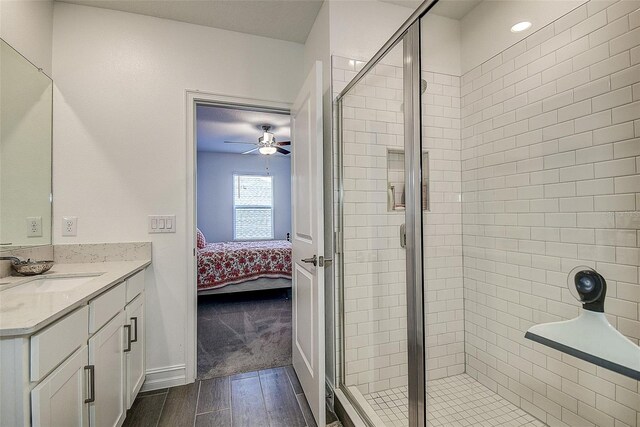 bathroom with hardwood / wood-style flooring, an enclosed shower, ceiling fan, and vanity