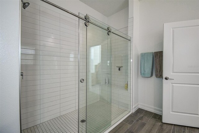 bathroom featuring wood-type flooring and a shower with door