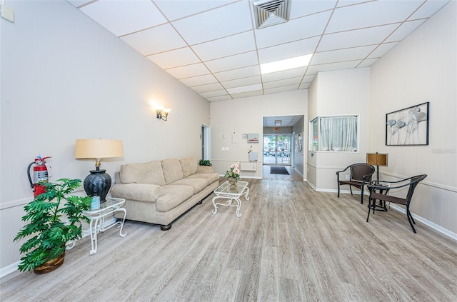 living area with visible vents, a drop ceiling, and wood finished floors