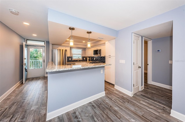 kitchen with backsplash, baseboards, white cabinets, stainless steel appliances, and dark wood-style flooring