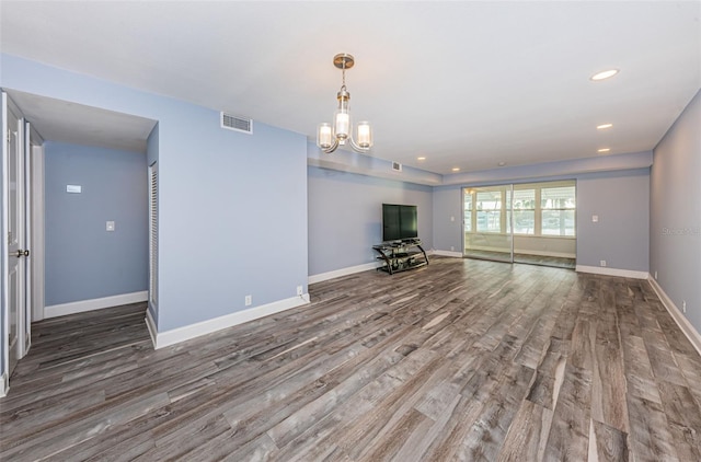 unfurnished living room featuring visible vents, wood finished floors, recessed lighting, baseboards, and a chandelier