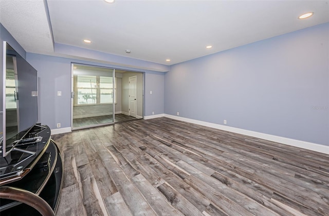 unfurnished living room with recessed lighting, baseboards, and wood finished floors