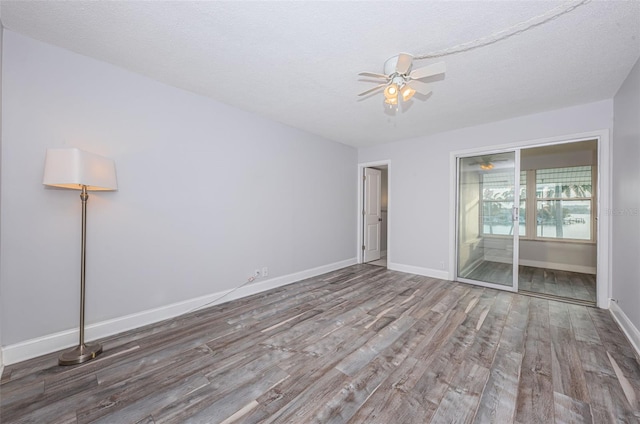 unfurnished bedroom featuring baseboards, a textured ceiling, and wood finished floors