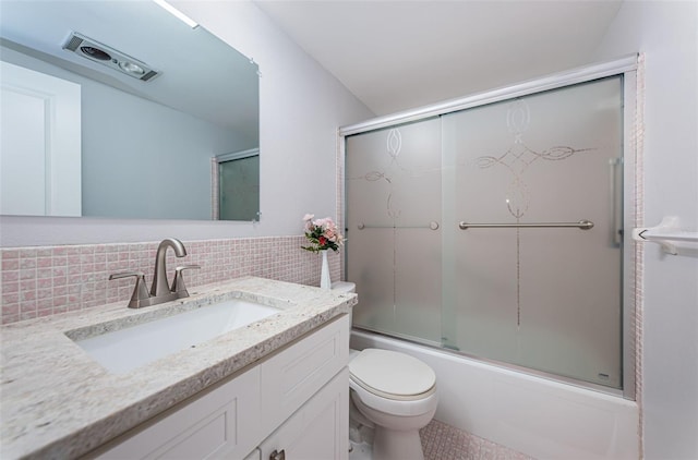 bathroom with decorative backsplash, bath / shower combo with glass door, toilet, and vanity