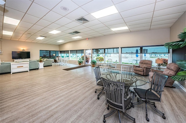 dining area with wood finished floors, visible vents, and a drop ceiling