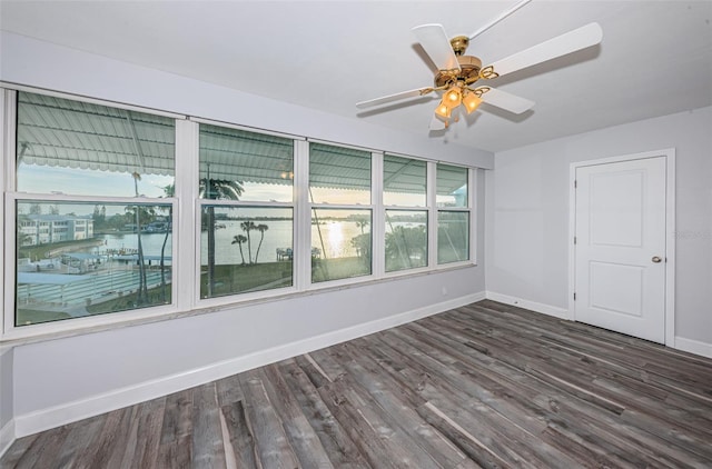 unfurnished room with wood finished floors, baseboards, and ceiling fan