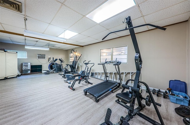 workout area featuring wood finished floors, visible vents, and a paneled ceiling