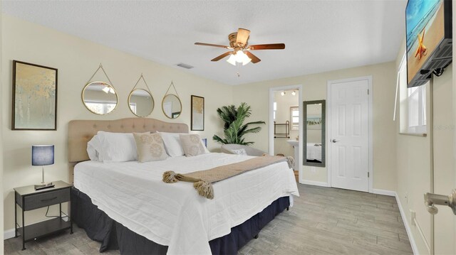 bedroom featuring ceiling fan, connected bathroom, and light hardwood / wood-style floors