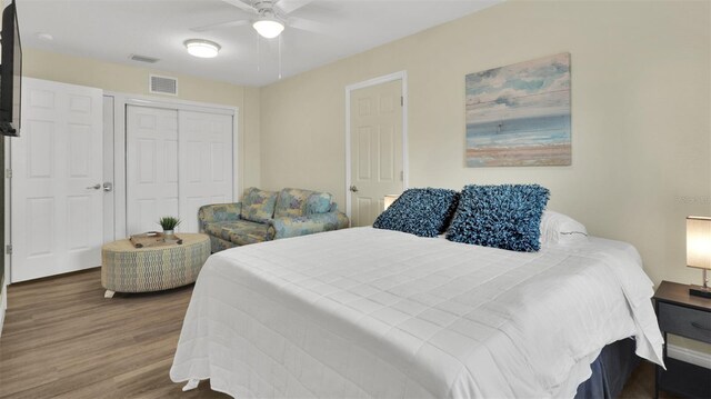 bedroom with a closet, ceiling fan, and dark hardwood / wood-style flooring