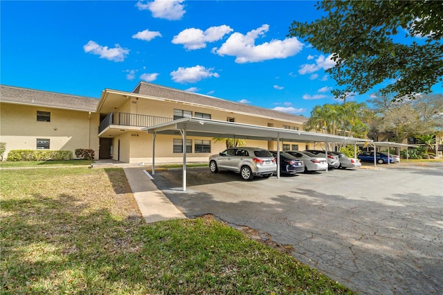 view of parking featuring a yard and a carport