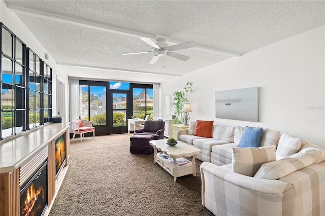 living room featuring french doors, a textured ceiling, dark carpet, and ceiling fan