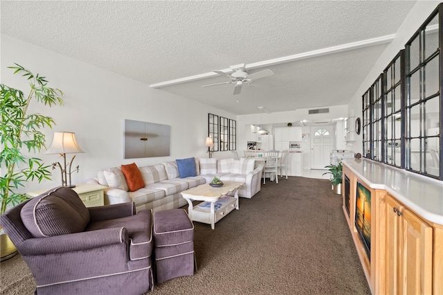 living room featuring a textured ceiling, carpet, and ceiling fan