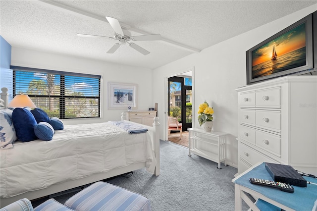 carpeted bedroom featuring ceiling fan and a textured ceiling