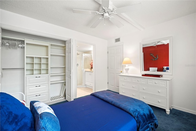 bedroom with carpet flooring, ceiling fan, a textured ceiling, a closet, and ensuite bathroom