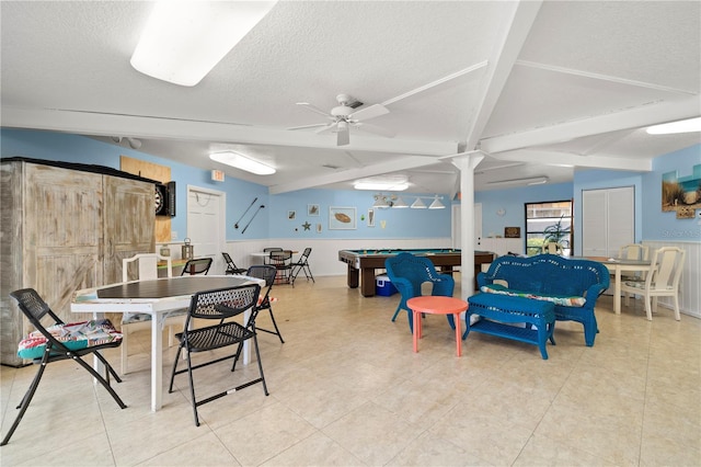 game room with light tile floors, ceiling fan, and beamed ceiling