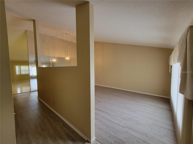 hall with a textured ceiling and hardwood / wood-style flooring