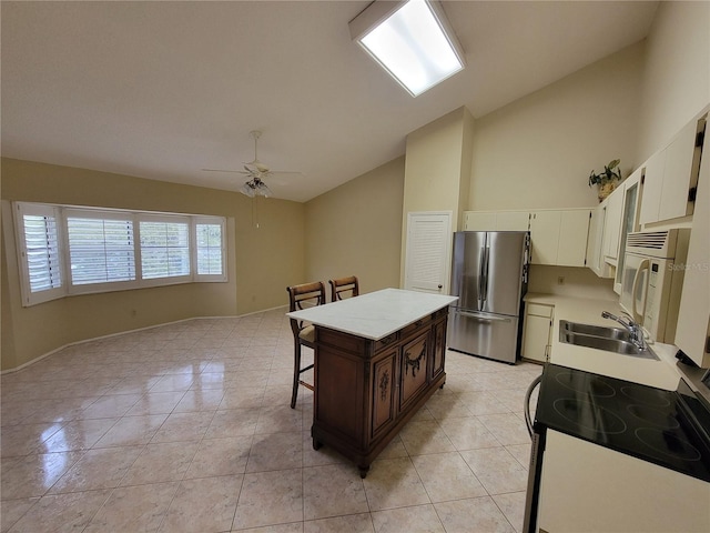 kitchen featuring stainless steel refrigerator, ceiling fan, light tile floors, and sink