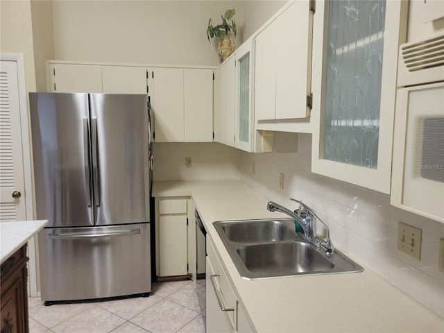 kitchen with sink, white cabinets, backsplash, stainless steel appliances, and light tile flooring