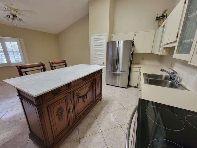 kitchen with light tile flooring, ceiling fan, stainless steel fridge, range, and sink