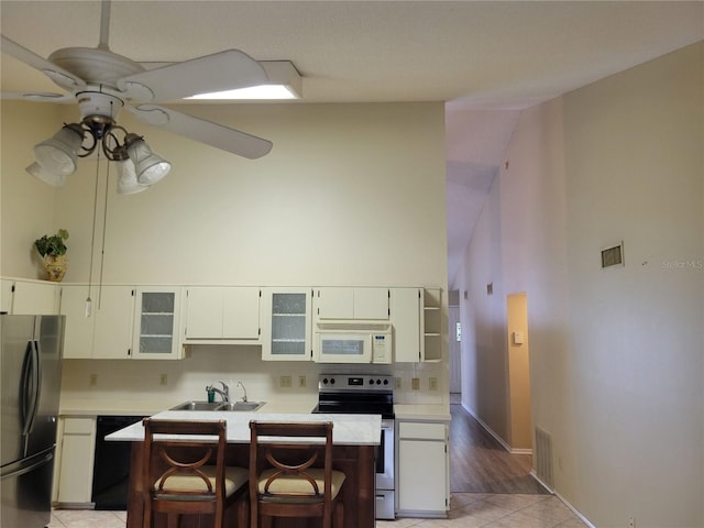 kitchen featuring ceiling fan, light tile flooring, sink, refrigerator, and stainless steel electric range