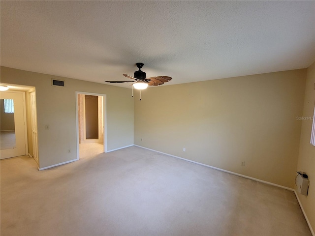 spare room with light carpet, a textured ceiling, and ceiling fan