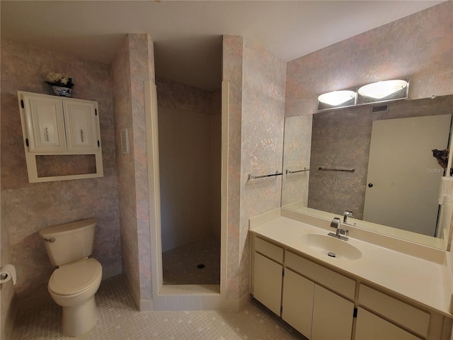 bathroom featuring a shower, toilet, vanity, and tile flooring