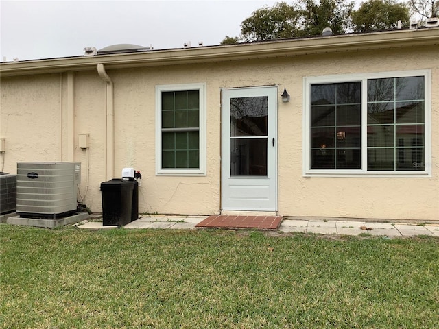 back of property featuring a lawn and central AC unit