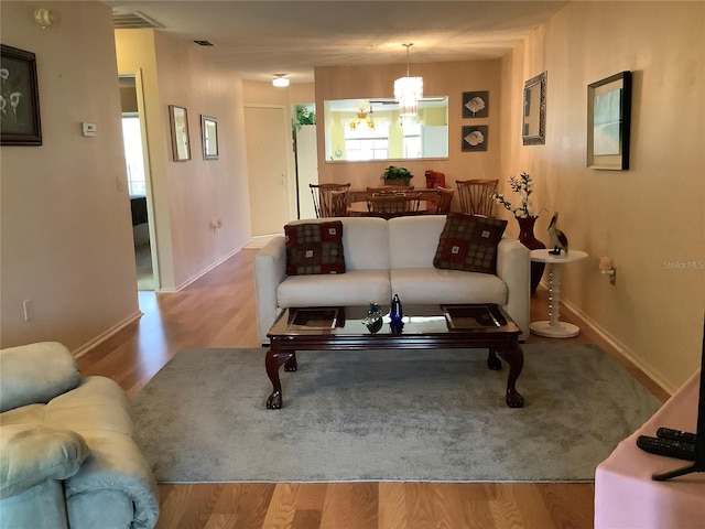 living room featuring light hardwood / wood-style floors and a notable chandelier