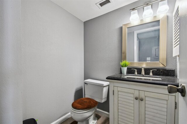 bathroom with hardwood / wood-style flooring, vanity, and toilet