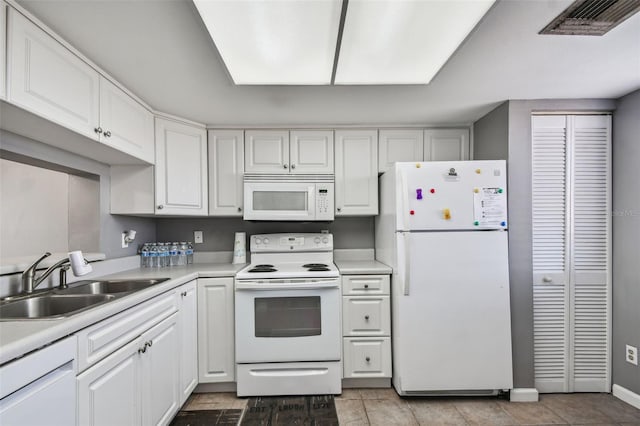 kitchen with white appliances, white cabinets, sink, and light tile floors