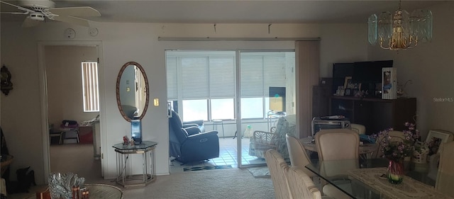 living room with carpet and ceiling fan with notable chandelier