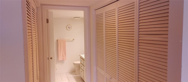 bathroom with toilet, vanity, a textured ceiling, and tile patterned floors