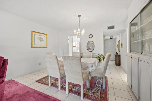 dining area with light tile patterned floors and an inviting chandelier