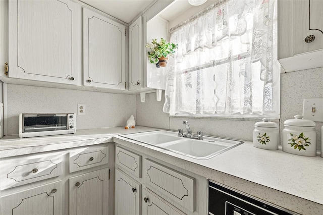 kitchen featuring dishwashing machine and sink