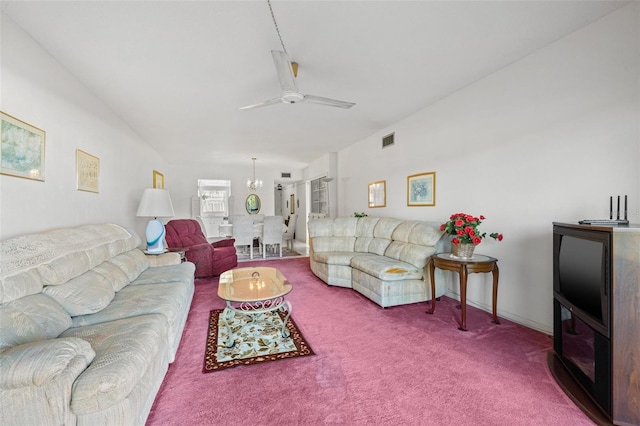 carpeted living room featuring ceiling fan with notable chandelier