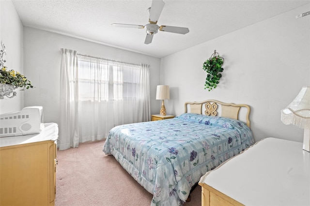 carpeted bedroom with ceiling fan and a textured ceiling