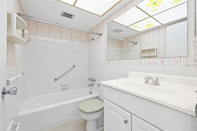 full bathroom featuring vanity, tiled shower / bath combo, and toilet