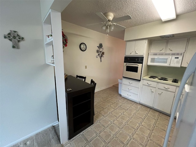 kitchen featuring a textured ceiling, white appliances, white cabinetry, and ceiling fan