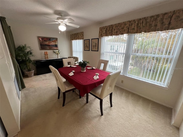 dining room featuring a textured ceiling, ceiling fan, and light colored carpet