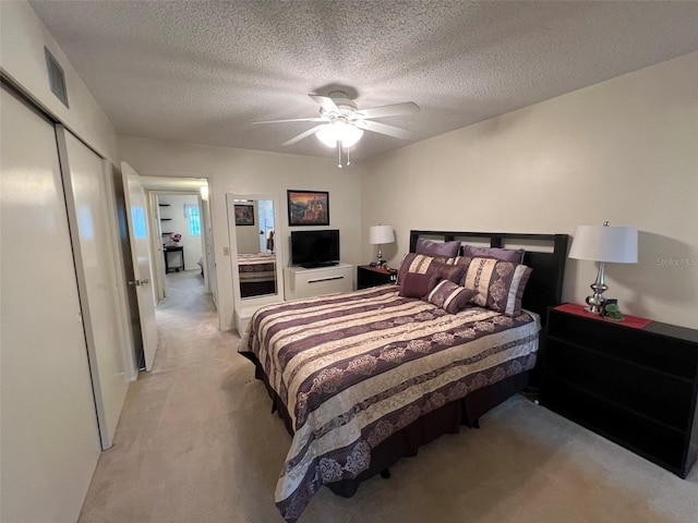 carpeted bedroom featuring a textured ceiling, ceiling fan, and a closet