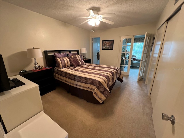 bedroom with ceiling fan, light colored carpet, and a textured ceiling