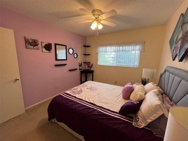 bedroom with ceiling fan, a textured ceiling, and light carpet