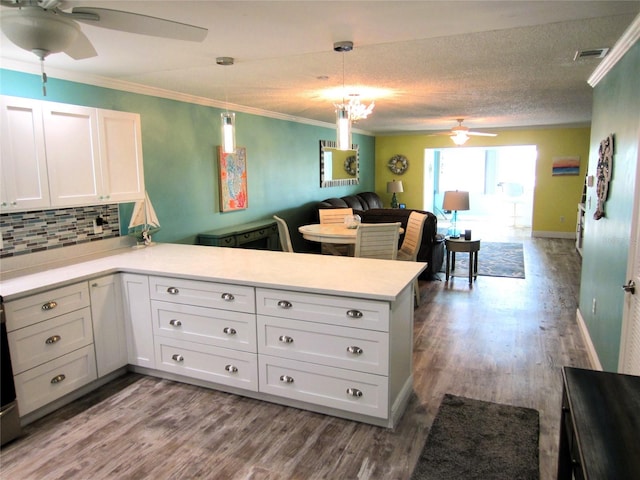 kitchen featuring kitchen peninsula, light hardwood / wood-style flooring, and white cabinetry